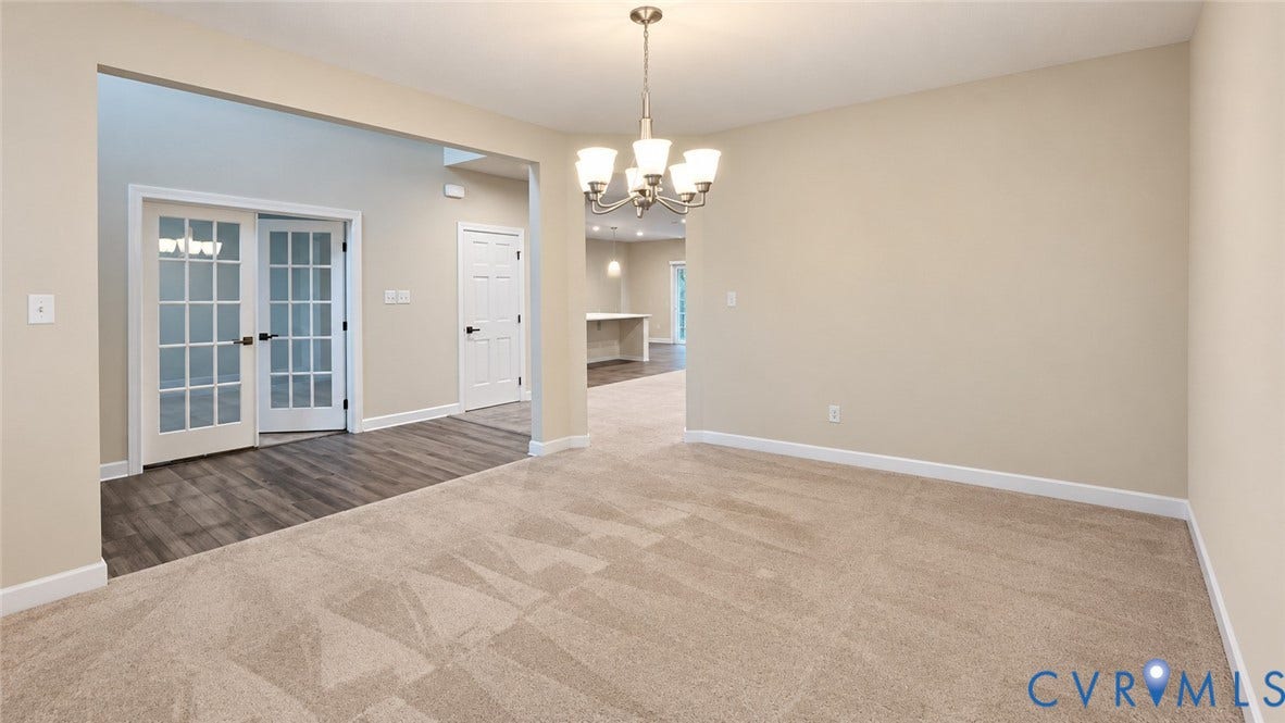 11500 Amara Drive, Chesterfield, VA 23838 Neutral-toned carpeting, wood-finish flooring, multi-pane French doors, and a decorative five-light chandelier
