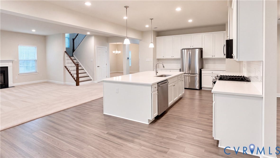 11500 Amara Drive, Chesterfield, VA 23838 Kitchen featuring white cabinetry, an expansive center island with stone-finish countertops, stainless steel appliances, pendant lighting, and wood-finish flooring