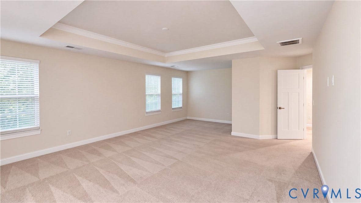 11500 Amara Drive, Chesterfield, VA 23838 Expansive room featuring a tray ceiling, neutral wall-to-wall carpeting, multiple windows with blinds, and a multi-panel interior door