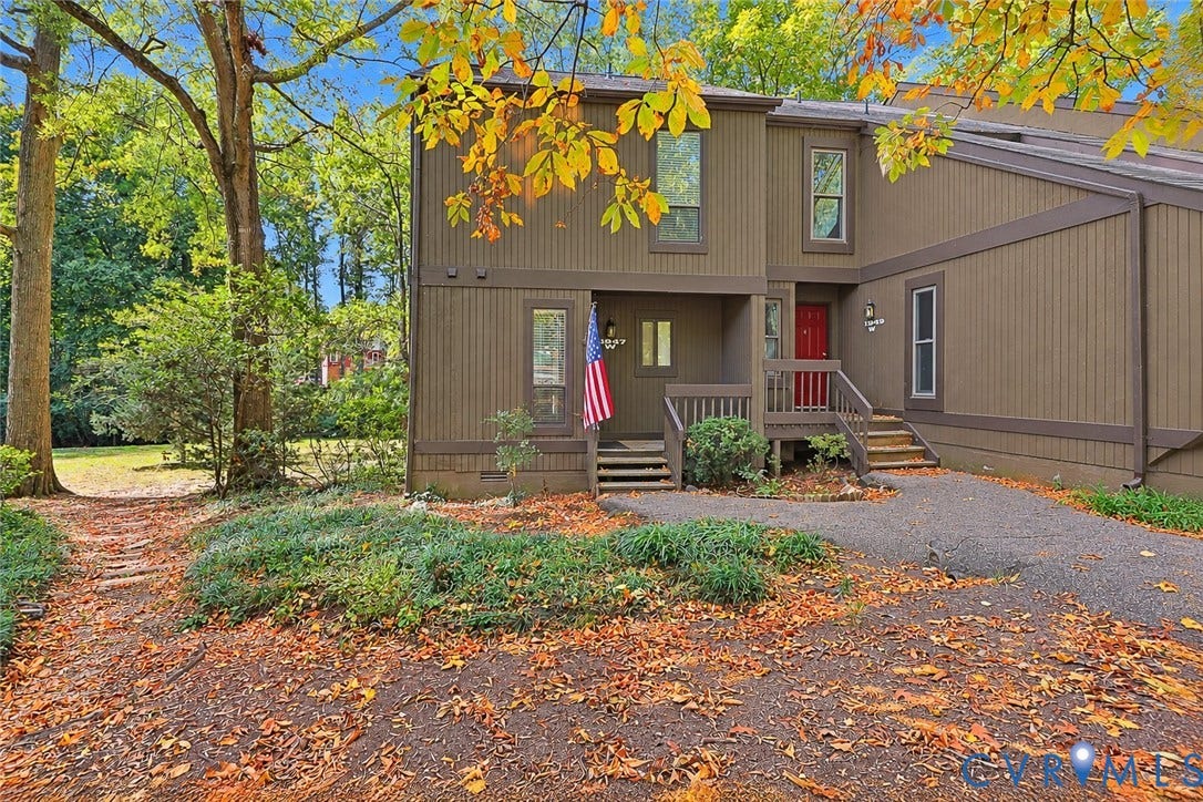 11947 W Briar Patch Drive, Chesterfield, VA 23113 Vertical wood siding exterior featuring a multi-level design, elevated wooden entry staircase, and mature tree landscaping