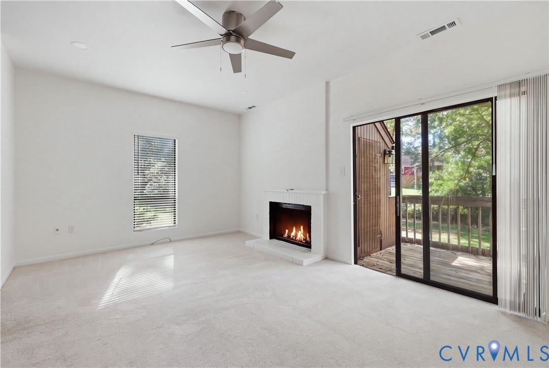11947 W Briar Patch Drive, Chesterfield, VA 23113 Living space featuring a white fireplace with a raised hearth, sliding glass doors, neutral carpeting, and a ceiling fan