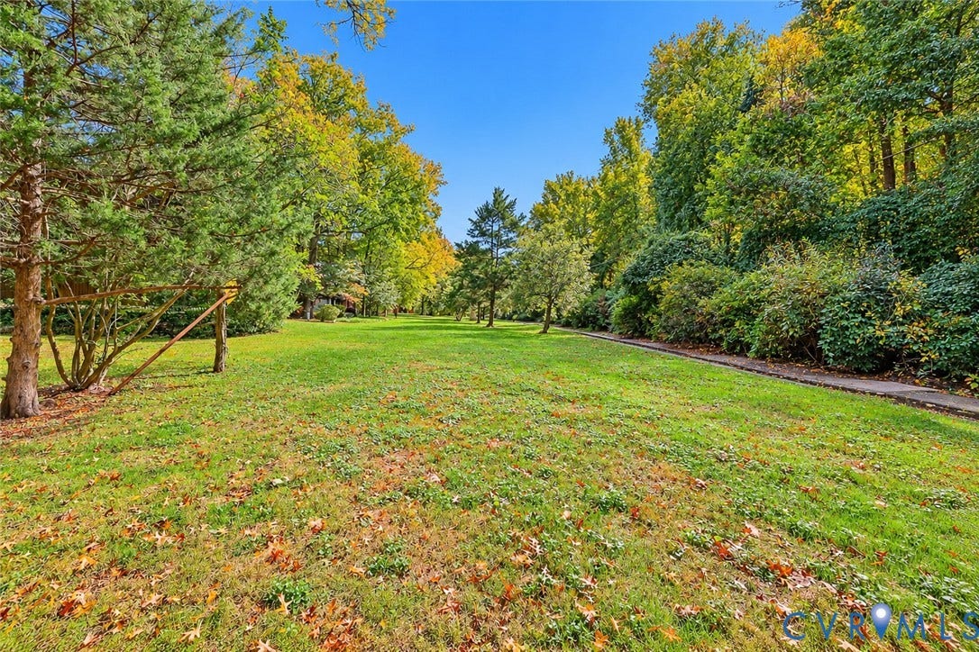 11947 W Briar Patch Drive, Chesterfield, VA 23113 Expansive backyard featuring a sprawling lawn, mature trees, and a paved stone pathway