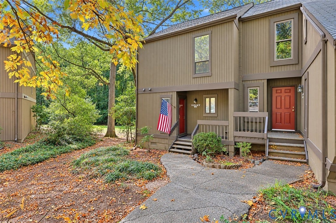 11947 W Briar Patch Drive, Chesterfield, VA 23113 Multi-level exterior featuring vertical wood siding, a red front door, covered wood porch, and a paved walkway