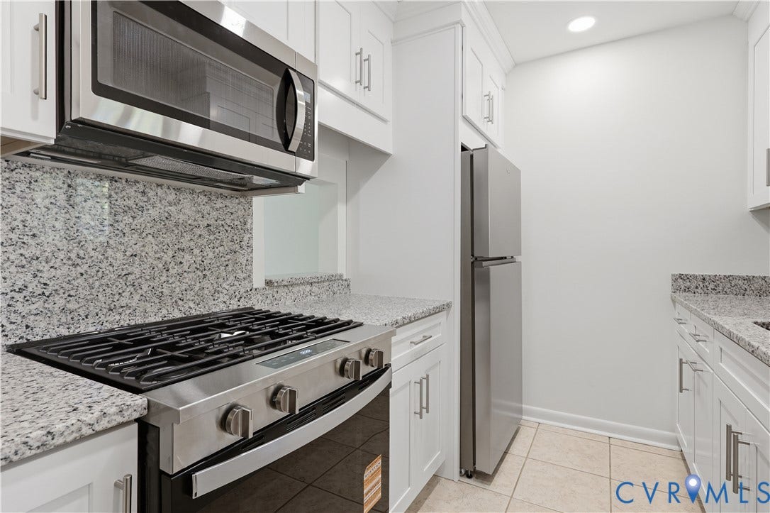11947 W Briar Patch Drive, Chesterfield, VA 23113 Kitchen featuring white cabinetry with metallic hardware, stone-finish countertops, tile flooring, and stainless steel appliances including a gas range and built-in microwave