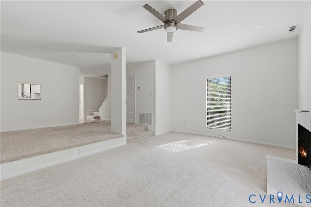 11947 W Briar Patch Drive, Chesterfield, VA 23113 Multi-level living area featuring neutral carpeting, a built-in white fireplace, recessed ceiling lighting, and a modern metal ceiling fan