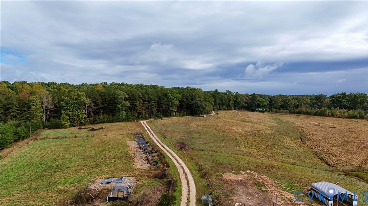 290 Western Lane, Appomattox, Appomattox, VA 24522 Expansive acreage featuring cleared pasture land, established tree lines, a gravel access road, and functional outbuildings