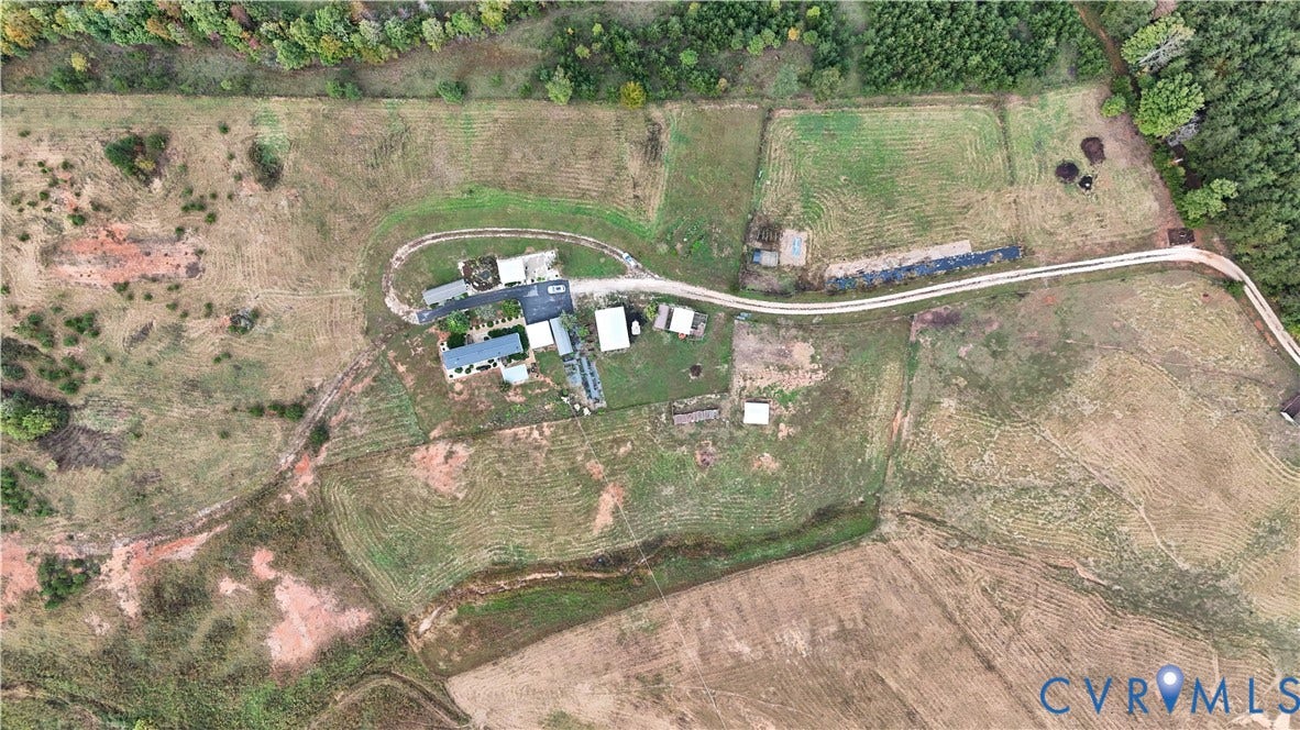290 Western Lane, Appomattox, Appomattox, VA 24522 Aerial perspective of a sprawling acreage featuring an expansive open field, multiple detached outbuildings, a private gravel driveway, and dense perimeter tree lines
