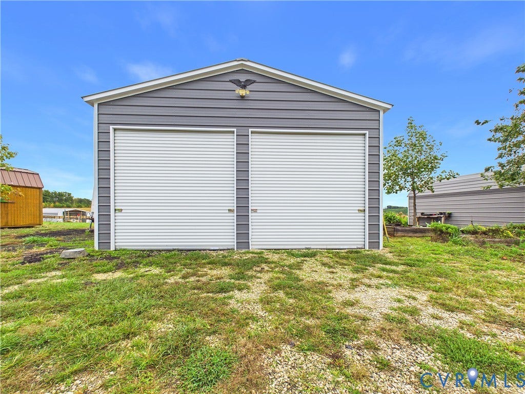 290 Western Lane, Appomattox, Appomattox, VA 24522 Detached two-car garage with grey horizontal siding, dual roll-up doors, and an exterior mounted light fixture