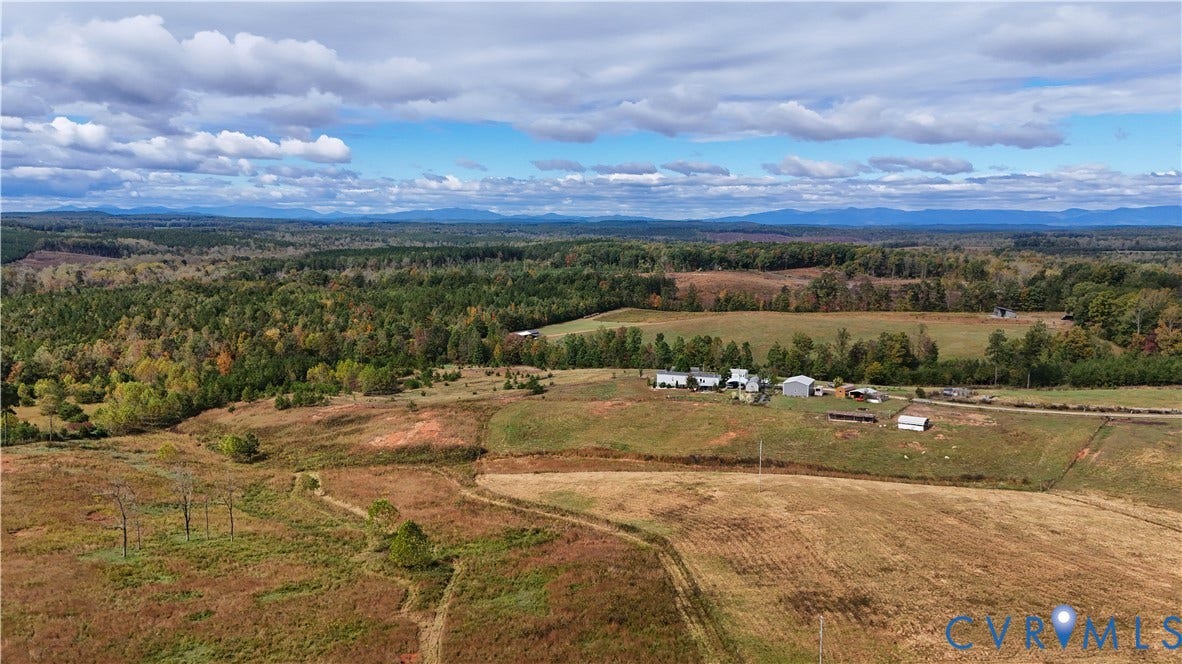 290 Western Lane, Appomattox, Appomattox, VA 24522 Expansive acreage featuring rolling open fields, scattered mature trees, multiple outbuildings, and distant mountain horizons