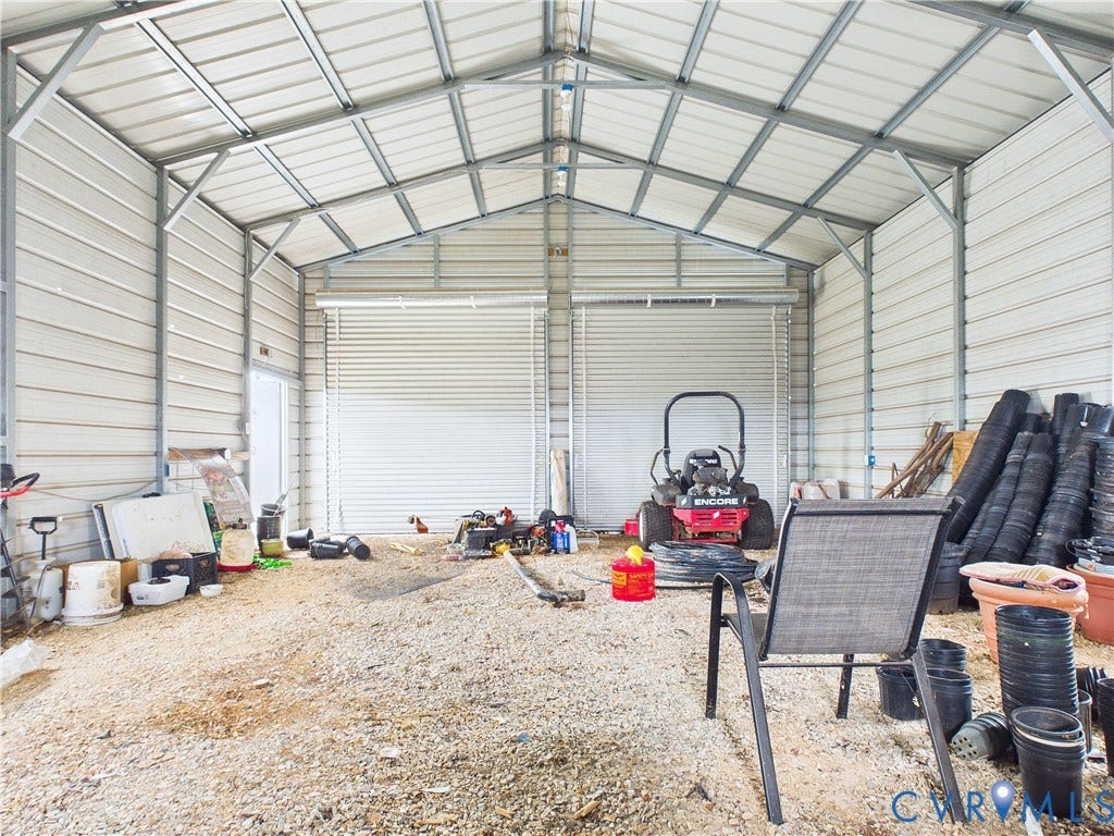 290 Western Lane, Appomattox, Appomattox, VA 24522 Detached metal storage structure featuring a vaulted ceiling, exposed steel framing, and dual roll-up garage doors