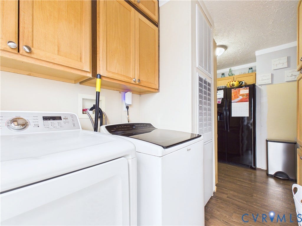 290 Western Lane, Appomattox, Appomattox, VA 24522 Laundry space featuring upper wood cabinetry, wood-finish flooring, and a built-in black refrigerator