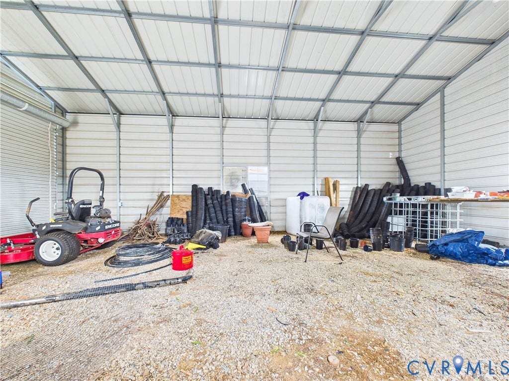 290 Western Lane, Appomattox, Appomattox, VA 24522 Detached metal-frame storage structure featuring corrugated metal wall panels, exposed steel truss ceiling, and gravel flooring