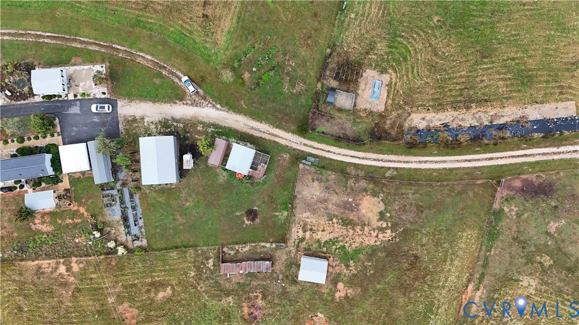 290 Western Lane, Appomattox, Appomattox, VA 24522 Aerial perspective of rural acreage featuring multiple outbuildings, open pasture land, and a gravel access road