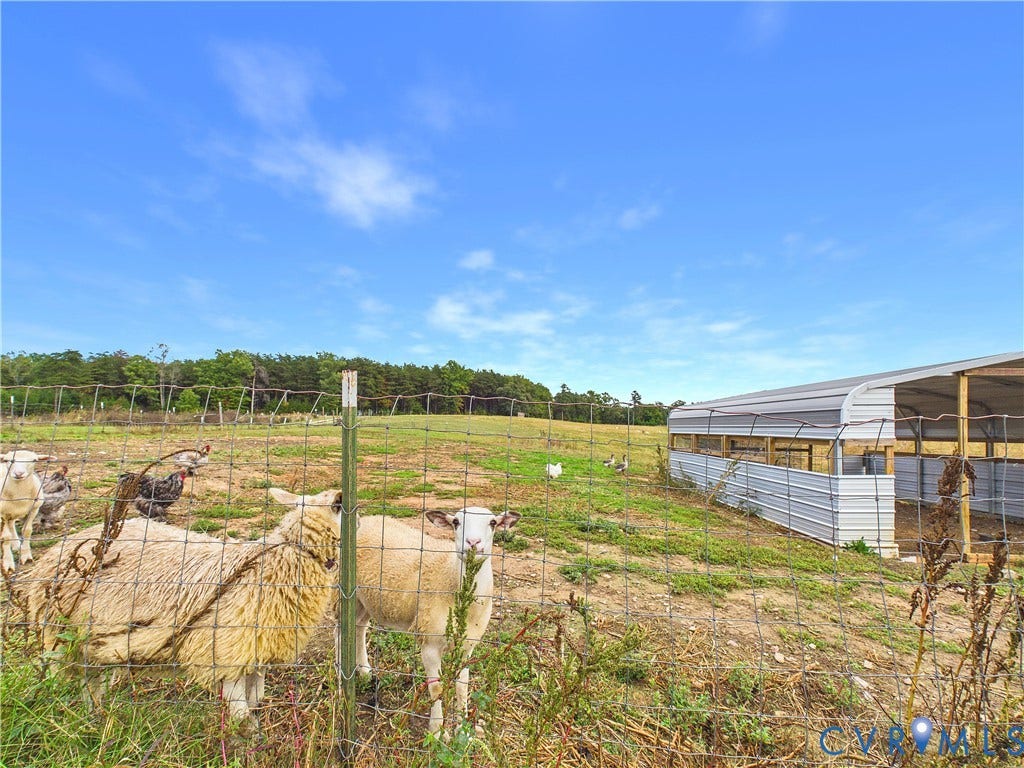 290 Western Lane, Appomattox, Appomattox, VA 24522 Expansive open pasture featuring perimeter wire fencing and a metal-clad agricultural structure