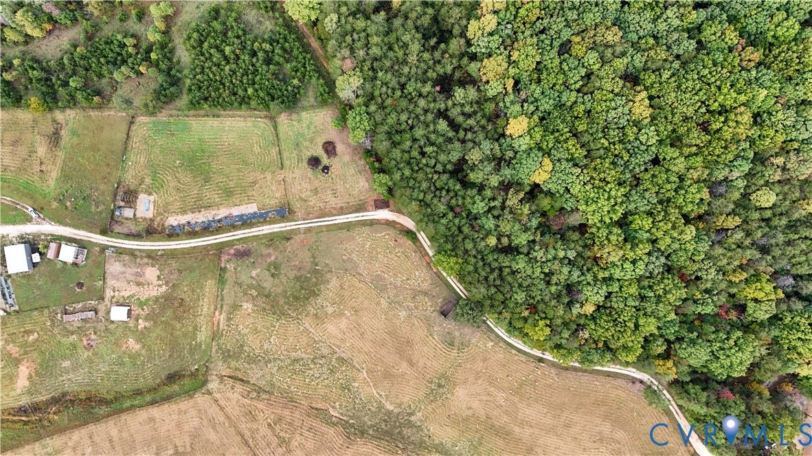 290 Western Lane, Appomattox, Appomattox, VA 24522 Aerial perspective featuring expansive acreage, mature forest borders, cleared pastureland, and winding gravel thoroughfares