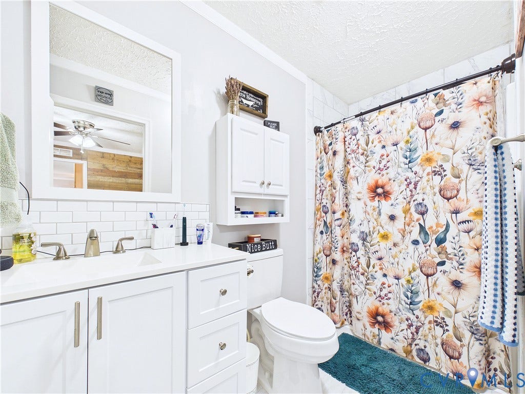 290 Western Lane, Appomattox, Appomattox, VA 24522 White vanity with integrated basin and undermount sink, white subway tile backsplash, wall-mounted medicine cabinet with integrated storage, and tub with shower surround