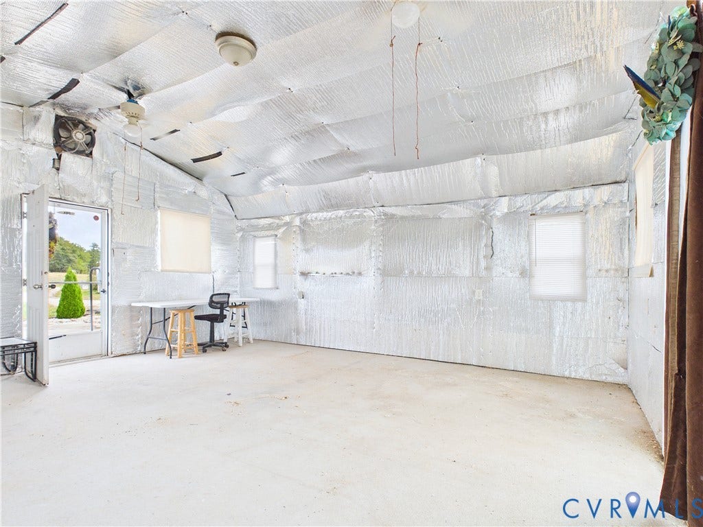 290 Western Lane, Appomattox, Appomattox, VA 24522 Interior space featuring concrete flooring, reflective metallic-finish wall and ceiling insulation, three windows, and an installed wall-mounted ventilation fan