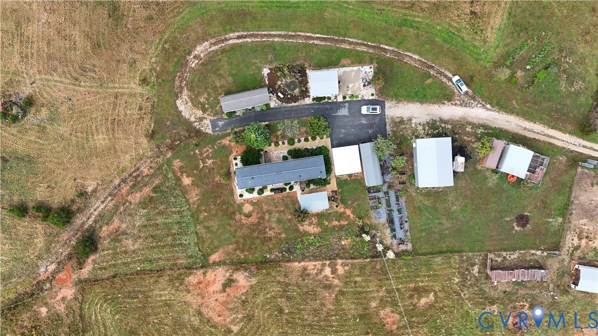 290 Western Lane, Appomattox, Appomattox, VA 24522 Aerial perspective of a sprawling property featuring multiple detached outbuildings, expansive pastureland, a paved driveway, and established landscaping