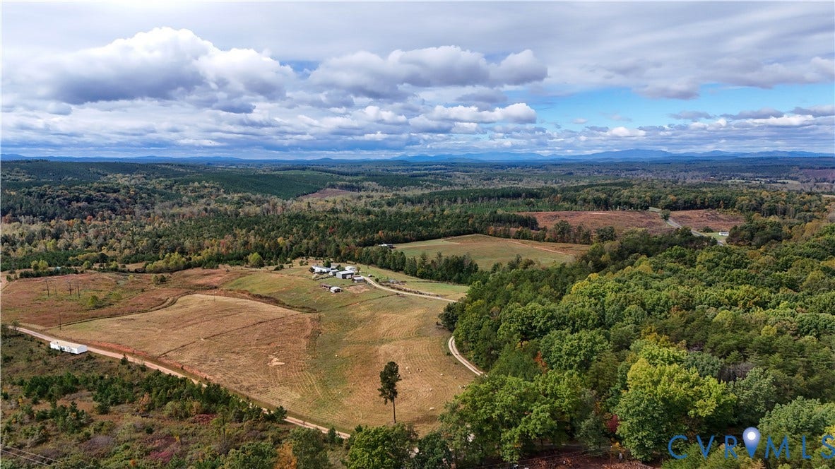 290 Western Lane, Appomattox, Appomattox, VA 24522 Expansive acreage featuring cleared pasture, dense woodlands, a private gravel road, and distant mountain topography