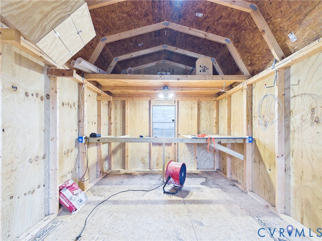 290 Western Lane, Appomattox, Appomattox, VA 24522 Outbuilding featuring exposed wood stud framing, plywood paneling, an elevated storage loft, and a built-in workbench