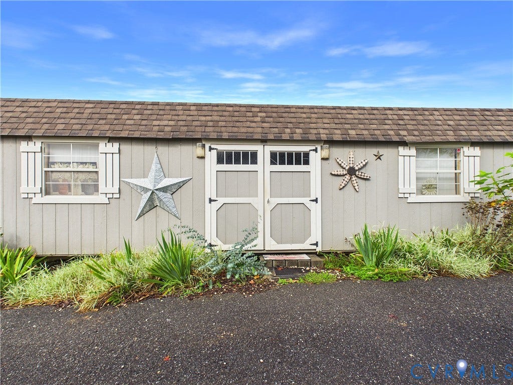 290 Western Lane, Appomattox, Appomattox, VA 24522 Storage structure featuring vertical panel siding, double doors with transom windows, dual windows with shutters, and asphalt shingle roofing