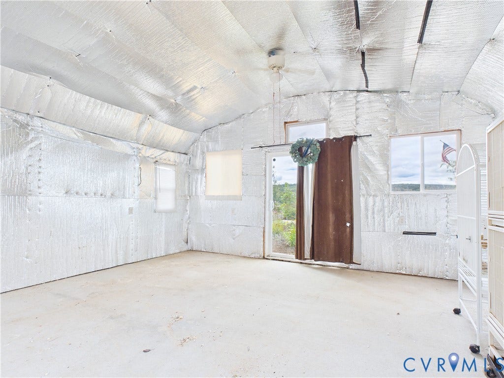 290 Western Lane, Appomattox, Appomattox, VA 24522 Enclosed structure featuring reflective foil insulation, vaulted ceiling with a central ceiling fan, concrete flooring, multiple windows, and a sliding glass door