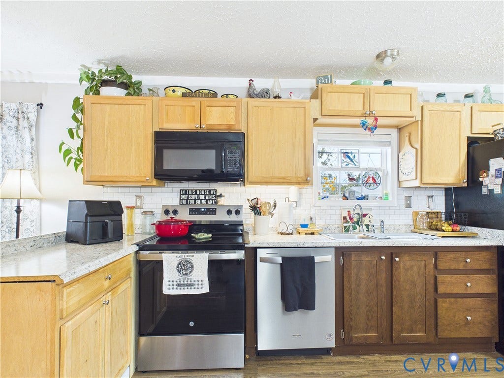 290 Western Lane, Appomattox, Appomattox, VA 24522 Kitchen featuring light and medium-toned cabinetry, light-colored countertops, subway tile backsplash, and stainless steel appliances