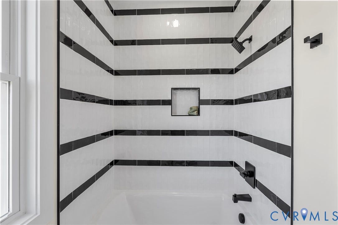 851 E Bank Street, Old Towne, Petersburg, VA 23803 Shower featuring white subway tile walls with horizontal black accent stripes, integrated square tile niche, and matte black fixtures