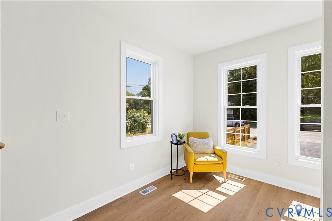 851 E Bank Street, Old Towne, Petersburg, VA 23803 Neutral-toned interior featuring wood-finish flooring and multiple double-hung windows with grid detailing