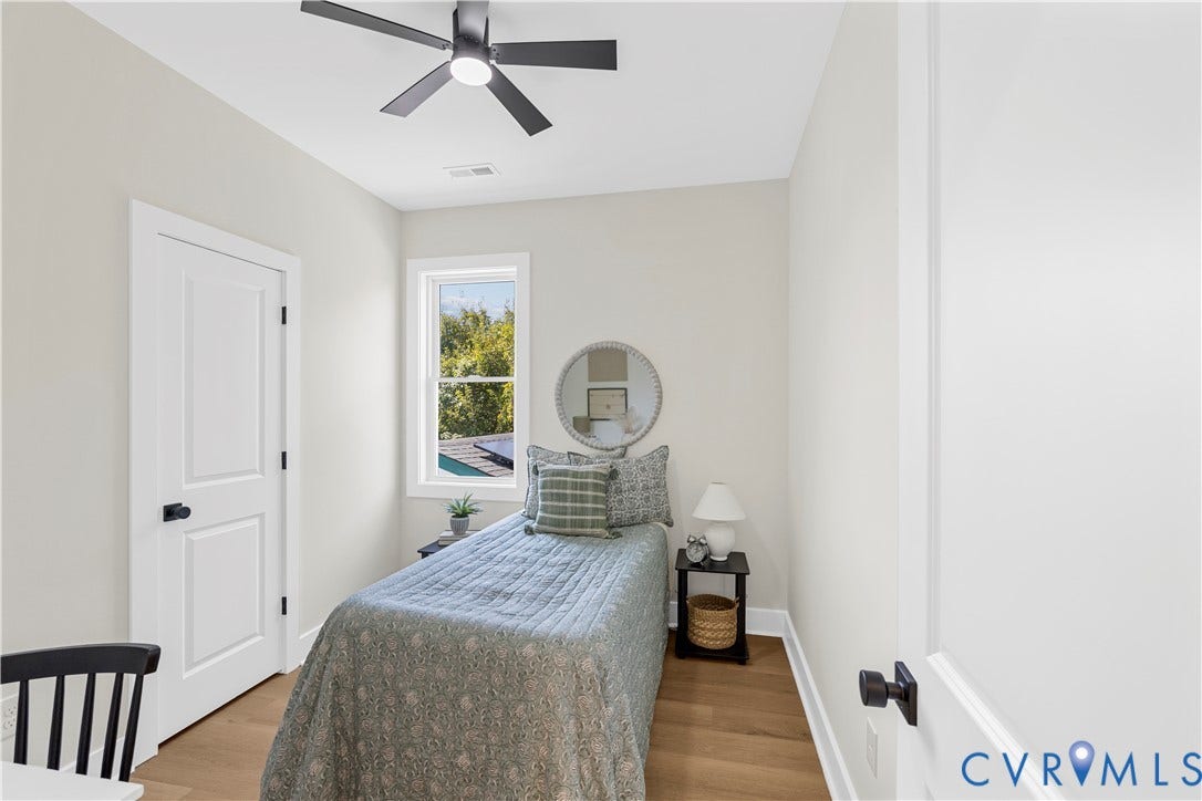 851 E Bank Street, Old Towne, Petersburg, VA 23803 Room featuring wood-finish flooring, a matte black ceiling fan, solid-core interior doors with matte black hardware, and an energy-efficient window