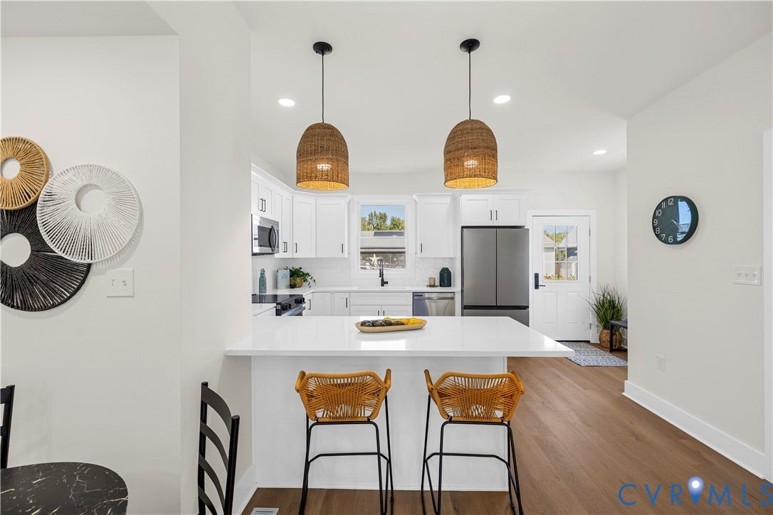 851 E Bank Street, Old Towne, Petersburg, VA 23803 Kitchen featuring white cabinetry, solid-surface countertops, wood-finish flooring, two woven pendant lights, and stainless steel appliances
