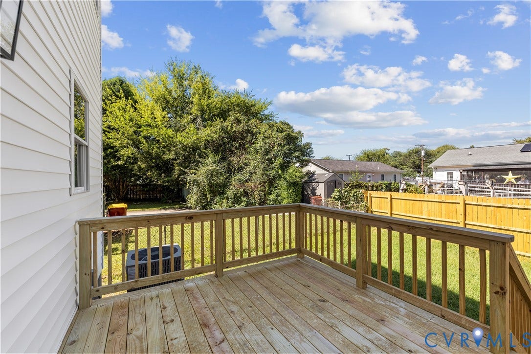 851 E Bank Street, Old Towne, Petersburg, VA 23803 Elevated wood deck featuring vertical baluster railings, wood plank flooring, and stairs, overlooking a fenced backyard