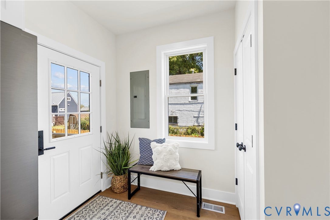 851 E Bank Street, Old Towne, Petersburg, VA 23803 Entryway featuring wood-finish flooring, a six-pane glass window door, a single-pane vertical window, and dual-panel closet doors with matte black hardware
