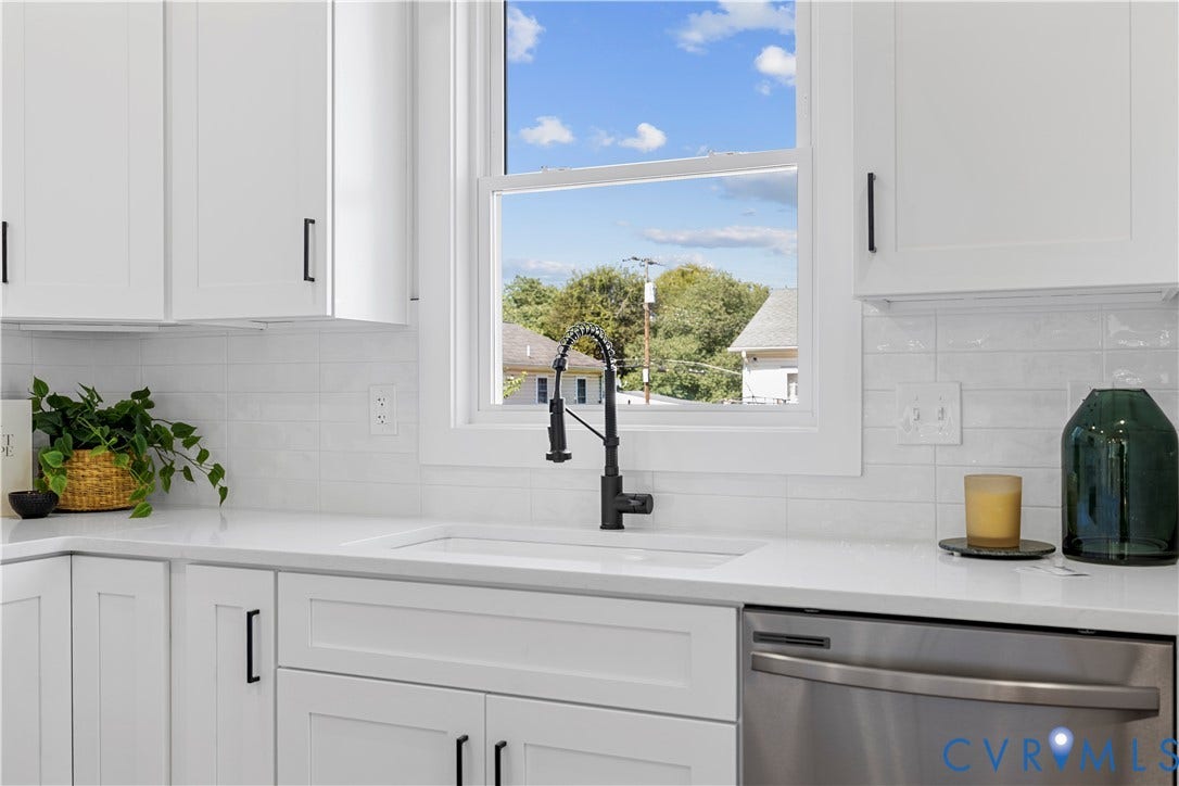851 E Bank Street, Old Towne, Petersburg, VA 23803 Kitchen featuring white shaker-style cabinetry, solid-surface countertops, horizontal subway tile backsplash, farmhouse-style apron sink with a matte black pull-down faucet, and stainless steel dishwasher