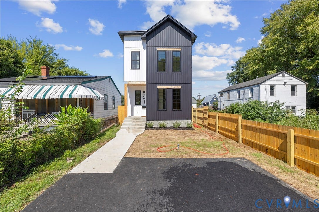 851 E Bank Street, Old Towne, Petersburg, VA 23803 Two-story architectural exterior featuring vertical panel siding, dark-toned metal cladding, a concrete front walkway, and a paved driveway