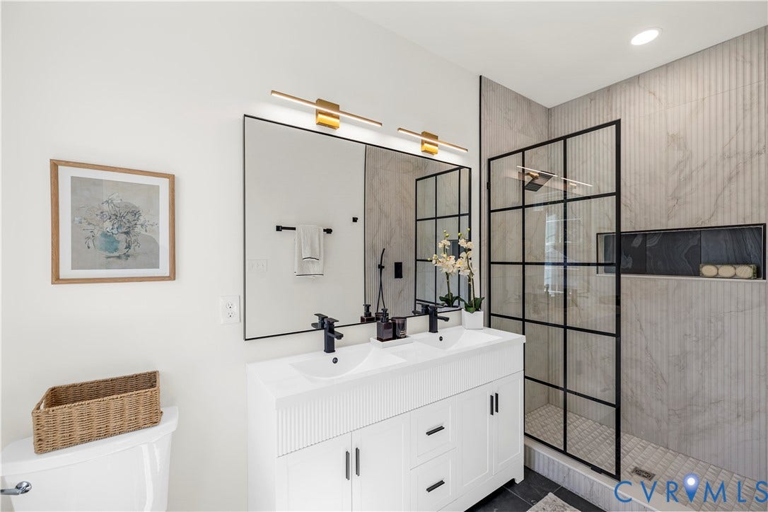 851 E Bank Street, Old Towne, Petersburg, VA 23803 White double vanity with integrated sinks, matte black hardware, large-format tiled walk-in shower with black grid enclosure, and recessed wall niche