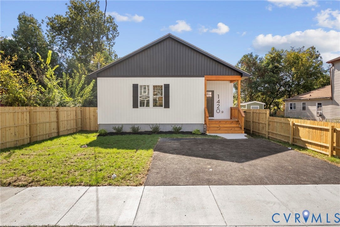1420 Ferndale Avenue, Petersburg, VA 23803 Single-story exterior featuring board-and-batten siding, a covered porch with exposed wood support beams, asphalt paved driveway, and a wood privacy fence