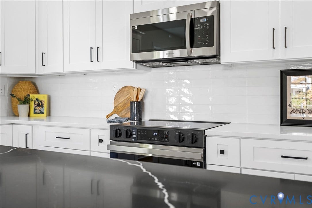 1420 Ferndale Avenue, Petersburg, VA 23803 Kitchen featuring white shaker-style cabinetry, dark stone-finish island countertop, white quartz perimeter countertops, subway tile backsplash, and stainless steel appliances