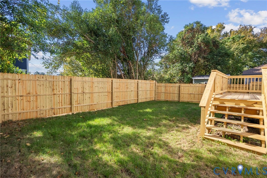 1420 Ferndale Avenue, Petersburg, VA 23803 Private backyard featuring a wood-plank privacy fence, manicured lawn, and raised wooden deck with integrated steps