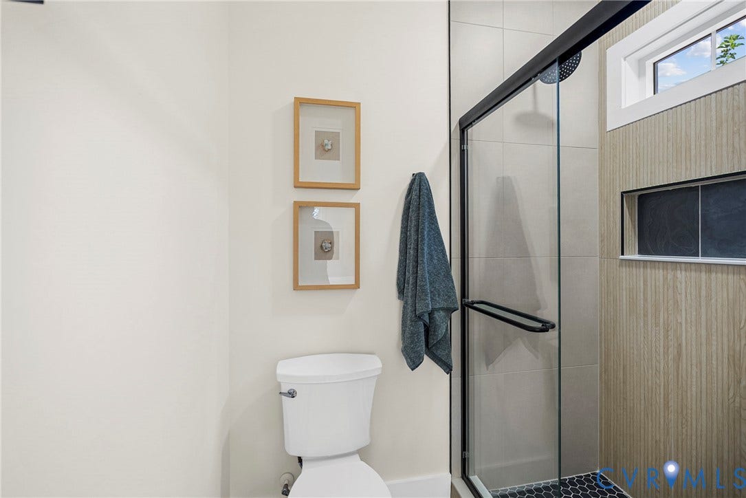 1420 Ferndale Avenue, Petersburg, VA 23803 Walk-in shower with matte black fixtures, glass enclosure, large-format tile surround, recessed wall niche, and hexagon floor tile