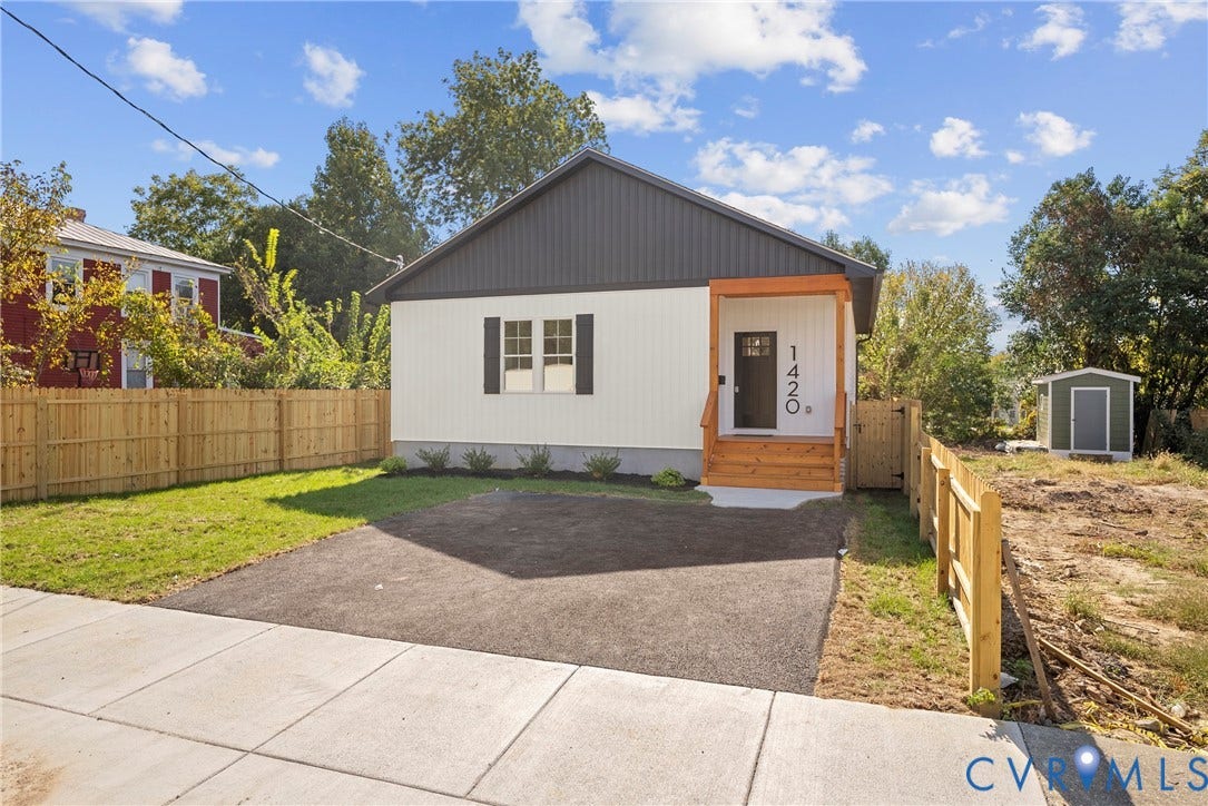 1420 Ferndale Avenue, Petersburg, VA 23803 Exterior featuring vertical siding, a wood-framed covered entrance, asphalt driveway, and perimeter wood fencing