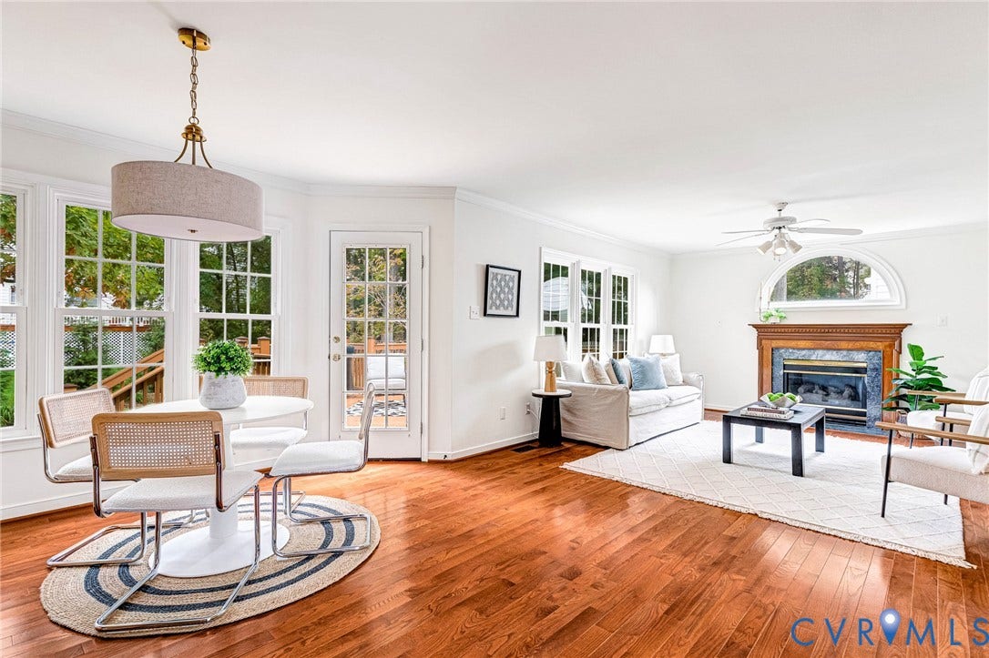 3629 Milbury Run Street, Henrico, VA 23233 Hardwood flooring, wood-mantled fireplace with stone surround, arched transom window, glass-paneled exterior door, and pendant lighting