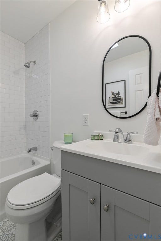 1809 Sussex Street, Whitcomb, Richmond, VA 23223 Bathroom featuring a grey vanity with a white countertop, oval mirror with a matte black frame, white subway tile shower surround, and chrome hardware