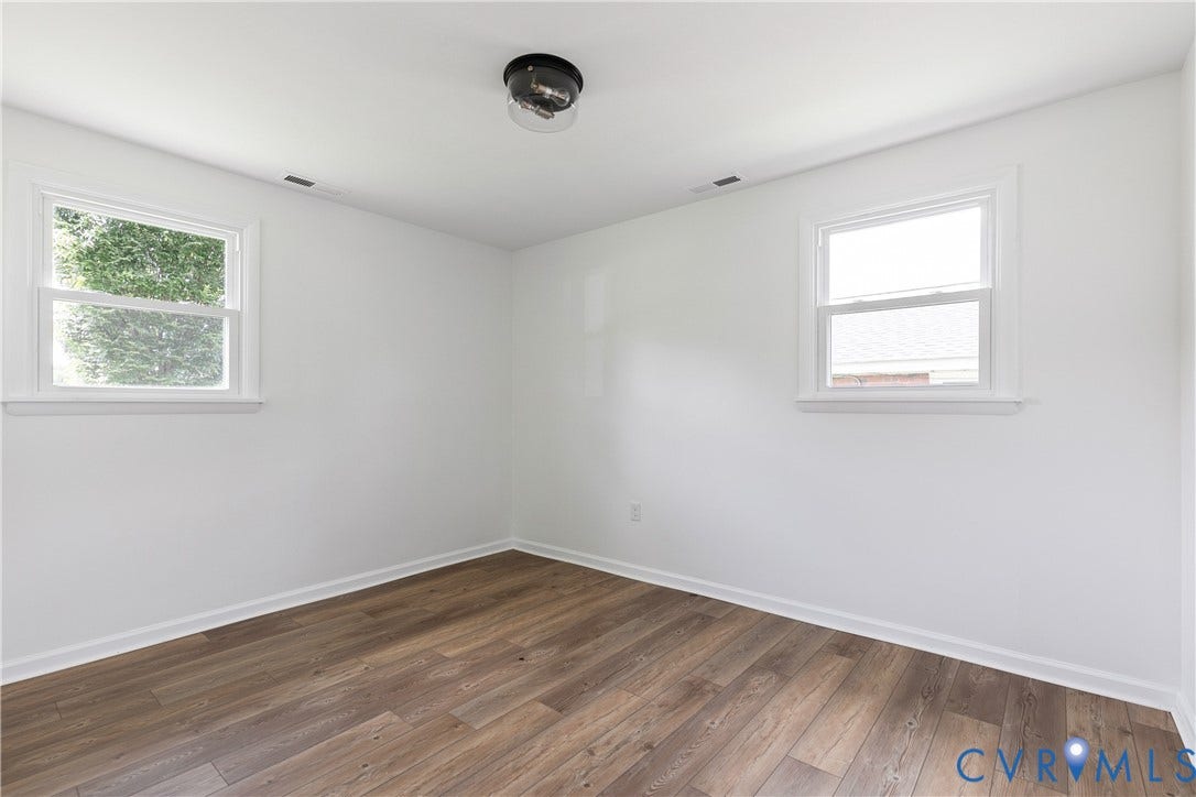 1809 Sussex Street, Whitcomb, Richmond, VA 23223 Interior space featuring wood-finish flooring, white walls, dual windows, and a central flush-mount ceiling fixture