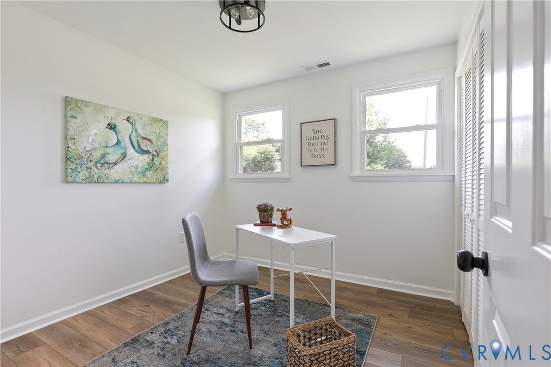 1809 Sussex Street, Whitcomb, Richmond, VA 23223 Room featuring wood-finish flooring, two double-hung windows, and white bifold closet doors with matte black hardware