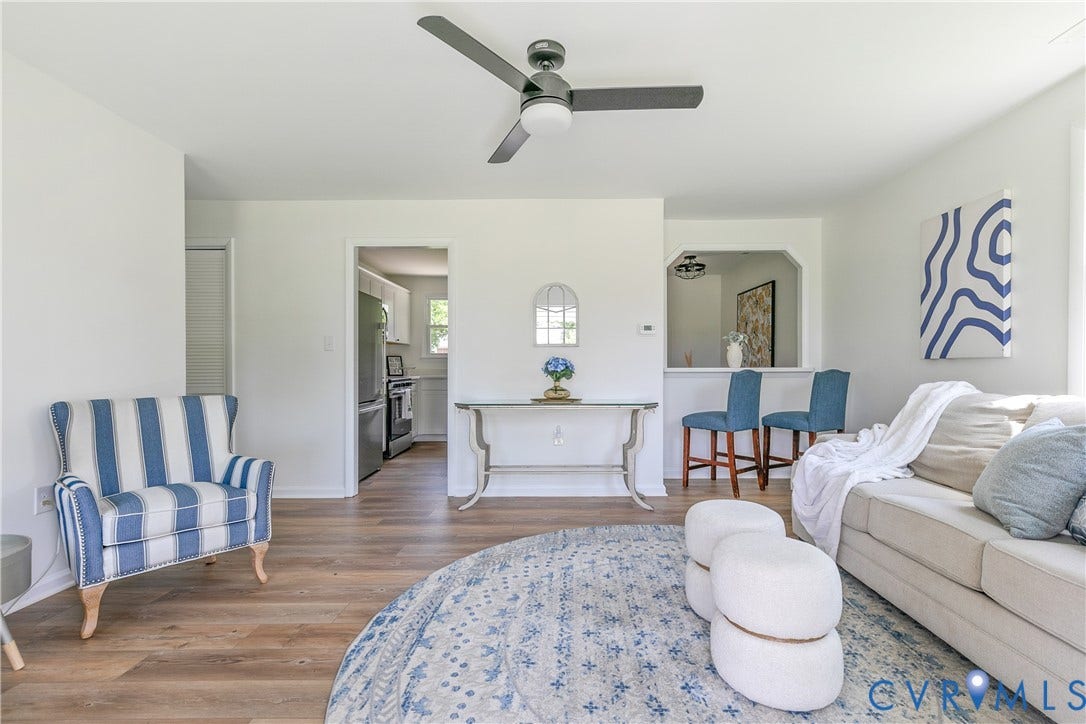 1809 Sussex Street, Whitcomb, Richmond, VA 23223 Living space featuring wood-finish flooring, a matte black three-blade ceiling fan with integrated lighting, and a pass-through opening to the kitchen