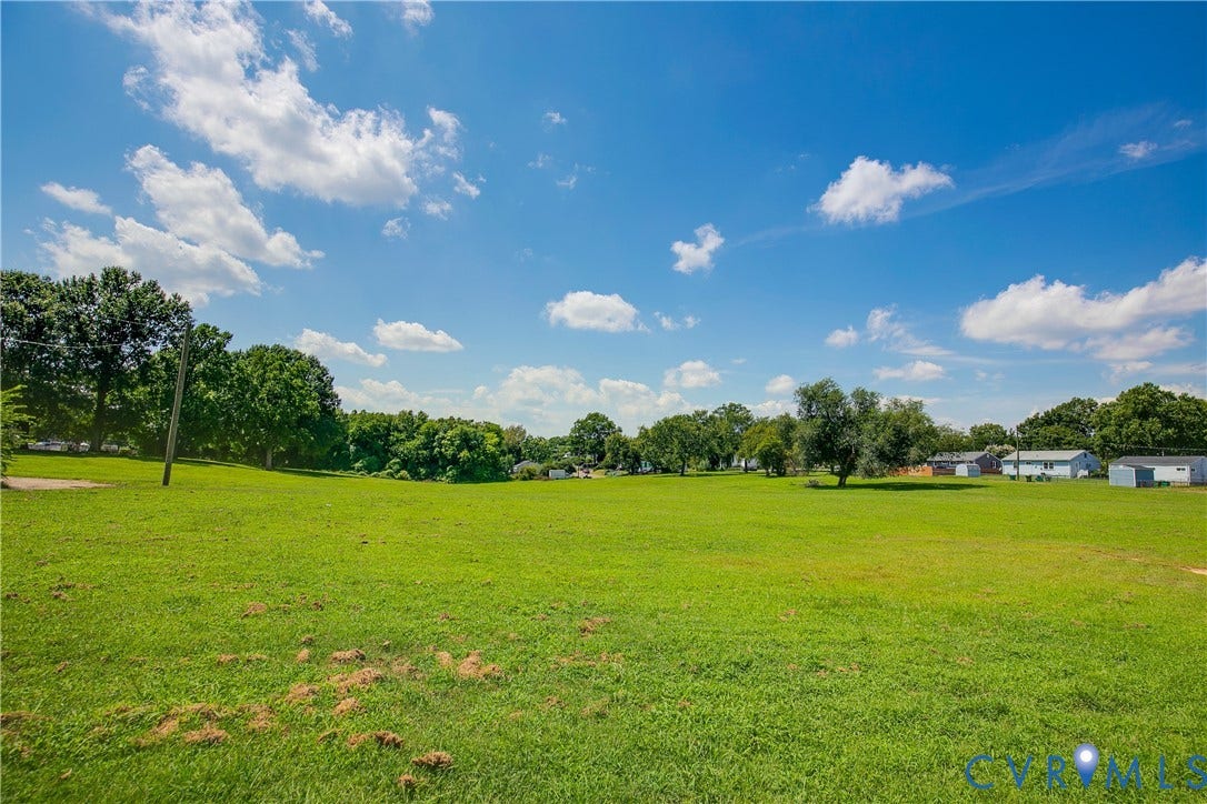 1809 Sussex Street, Whitcomb, Richmond, VA 23223 Expansive parcel of land featuring level topography, open grassy terrain, and clusters of mature trees