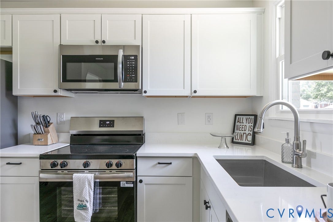 1809 Sussex Street, Whitcomb, Richmond, VA 23223 Kitchen featuring white shaker-style cabinetry, solid-surface countertops, stainless steel appliances, and an undermount sink with a gooseneck faucet