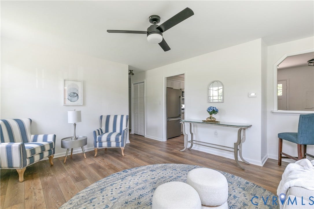 1809 Sussex Street, Whitcomb, Richmond, VA 23223 Living area featuring wood-finish flooring, a matte black ceiling fan with integrated lighting, and a partial wall opening