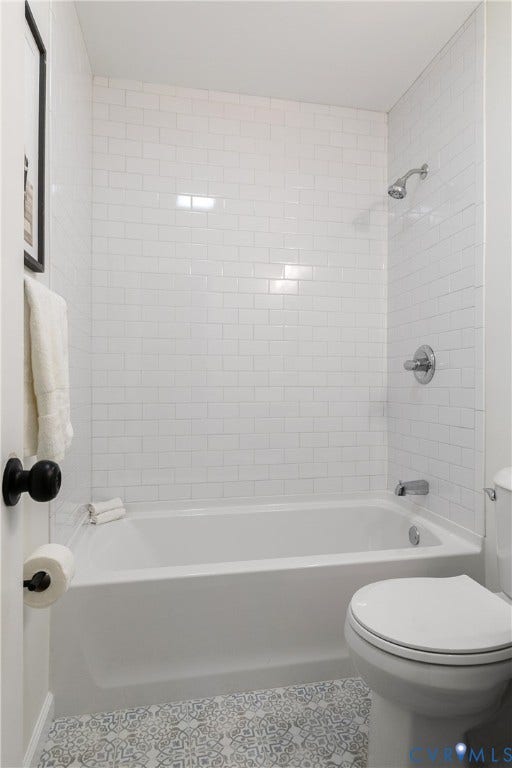 1809 Sussex Street, Whitcomb, Richmond, VA 23223 Full-height white subway tile surround, integrated soaking tub, polished chrome shower fixtures, and patterned decorative tile flooring
